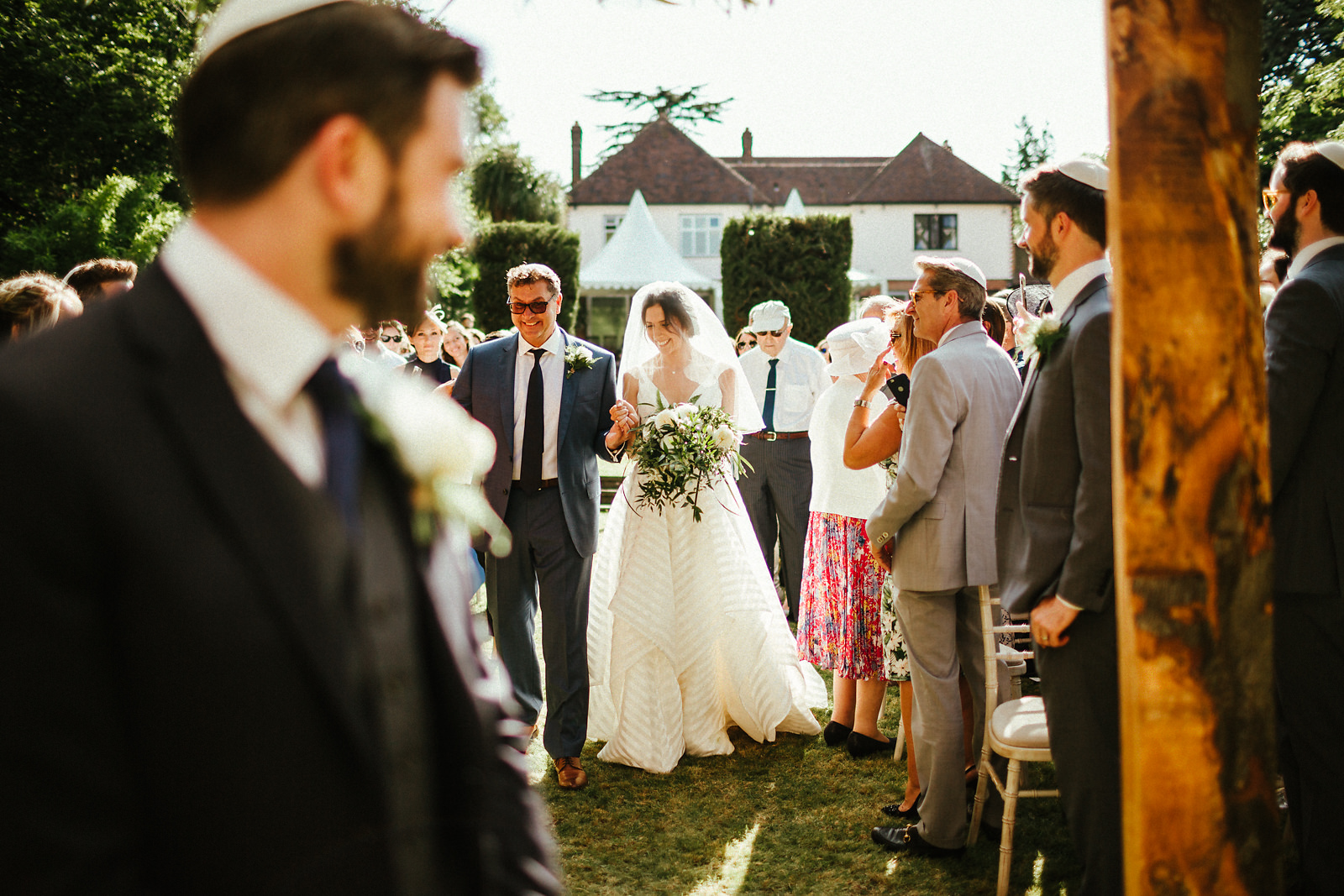 Father of the bride walking down the aisle in summer wedding