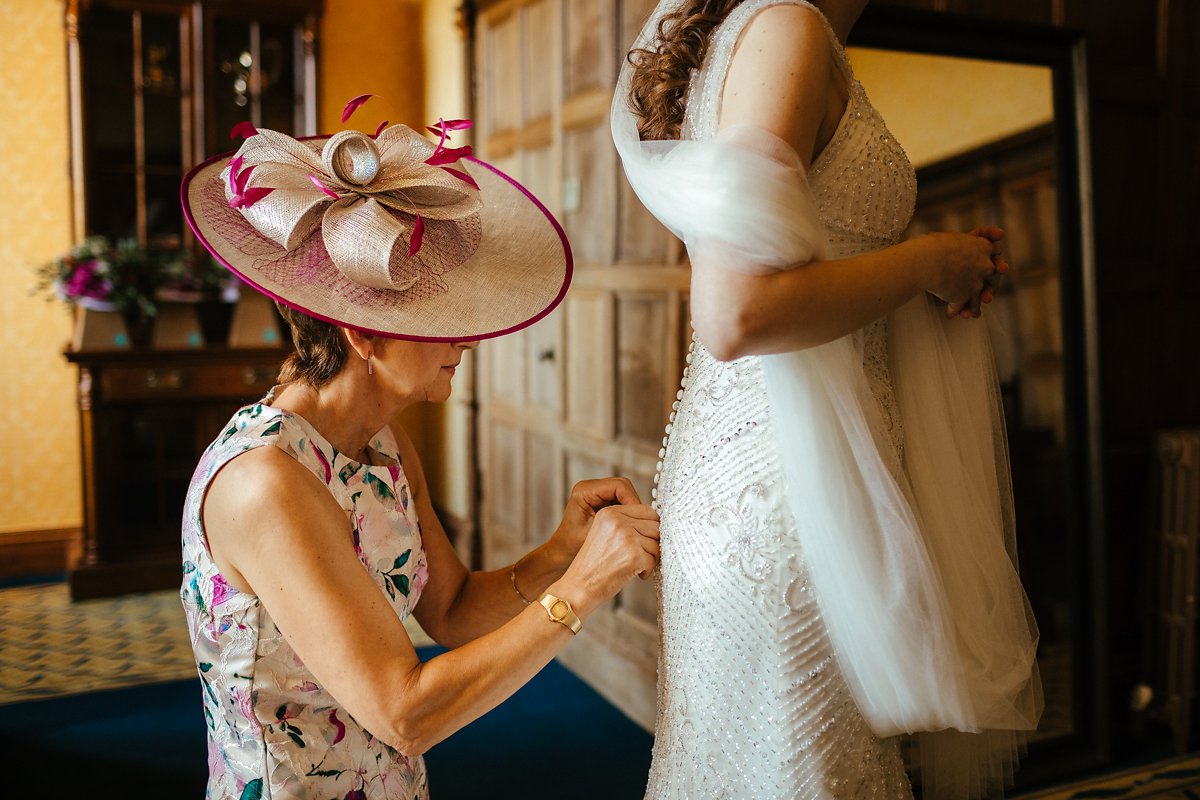 Mum helping bride to get dressed