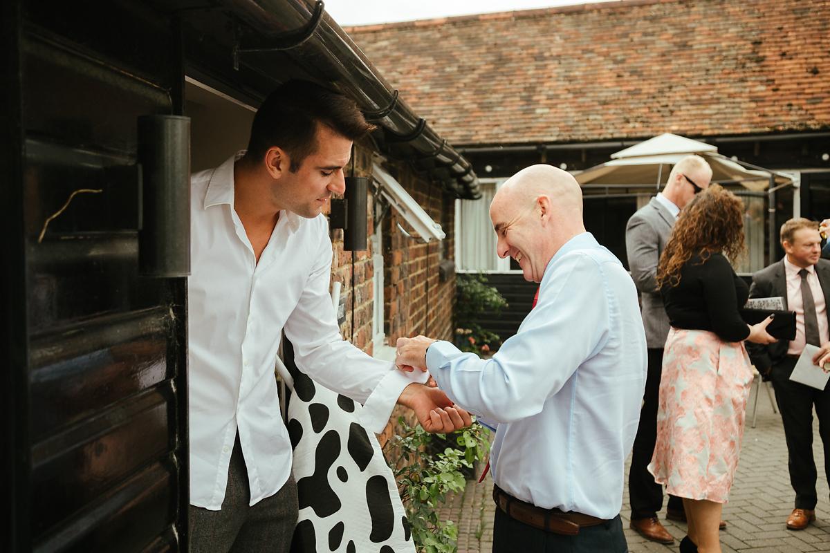 Guests helping groomsmen getting ready