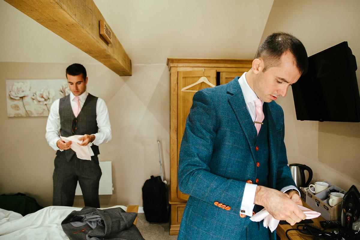 Guests helping groomsmen getting ready