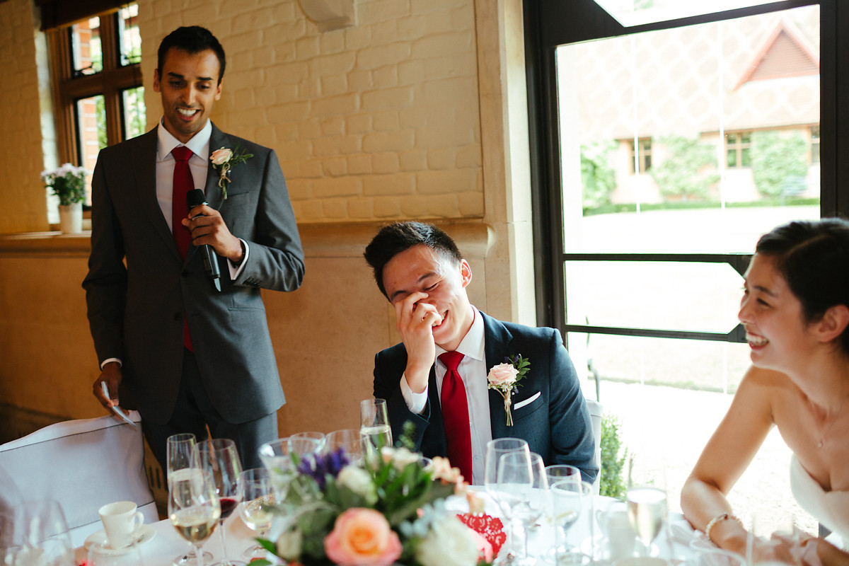 Groom laughing during best man speech